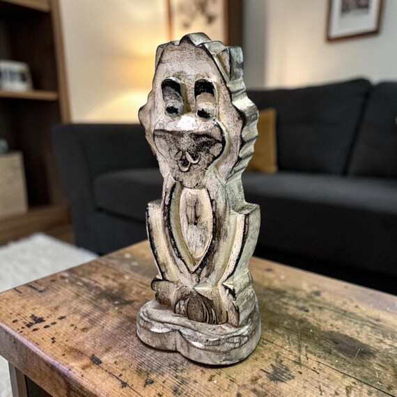 A carved wooden monkey that juggles glasses, pens, and your phone simultaneously — Tiki-bar energy meets practical desk organizer in one weird little guy.