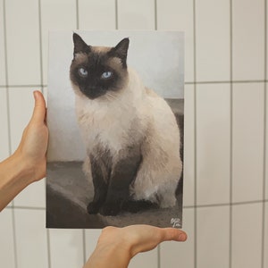 May include: A painting of a Siamese cat with blue eyes, sitting on a brown surface. The cat is looking directly at the viewer.