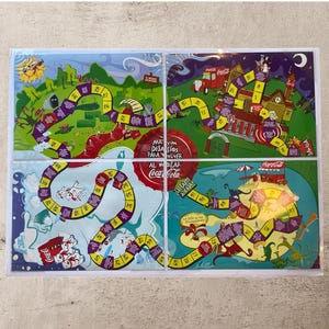 May include: A set of four colorful board game panels featuring winding paths, numbered spaces, and various illustrations. The games have a Coca-Cola theme, with text in Spanish. The panels are framed in white.