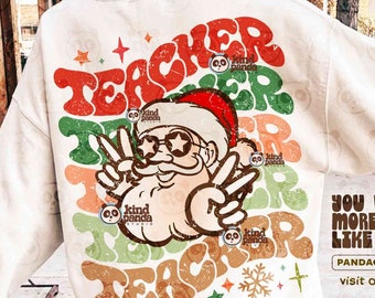 Puede incluir: Sudadera crema con un diseño retro que presenta a Papá Noel con gafas de sol y haciendo el signo de la paz. La palabra "TEACHER" está superpuesta en varios colores. El diseño incluye el texto "YOU WANNA MORE DESIGN LIKE THIS?" y "PANDACREATIVE.ORG".