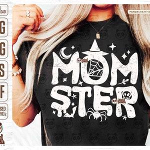 May include: A black t-shirt with a white graphic design that says "Momster" with a witch's hat, spider web, spider, and stars.