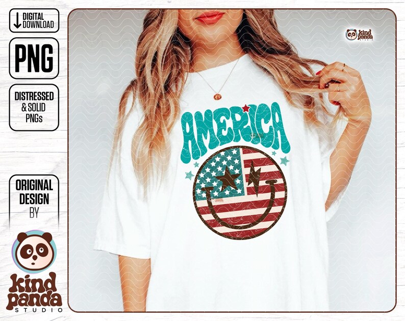 May include: A white t-shirt with a blue and red smiley face design. The smiley face is made up of the American flag and the text "AMERICA" is written in a retro font above the smiley face.