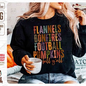 K&ouml;nnte beinhalten: Ein schwarzes Sweatshirt mit einem bunten Grafikdesign, auf dem "Flannels, Bonfires, Football, Pumpkins, Fall y'all" steht.
