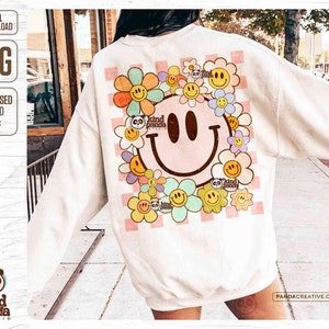 May include: Cream sweatshirt with a large smiley face and floral design. The back has a checkered pattern and the words "kind panda studio". The design includes the text "digital download" and "distressed & solid PNGs". The design is in a retro style.