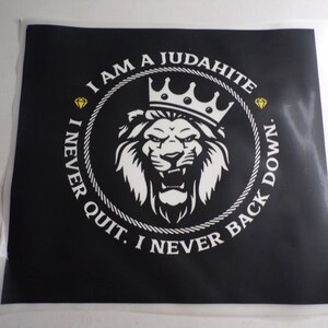 May include: Black and white graphic design with a lion wearing a crown inside a circle with the text "I AM A JUDAHITE. I NEVER QUIT. I NEVER BACK DOWN."