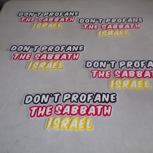 Pode incluir: Cinco patches bordados com o texto "Don't Profane The Sabbath Israel" em letras pretas, vermelhas e amarelas sobre um fundo branco.