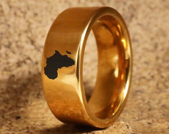 May include: A gold ring with a black outline of the continent of Africa on the band.