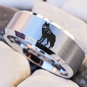 May include: A silver ring with a brushed finish and a black wolf silhouette design.