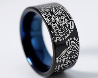 May include: A black and blue tungsten carbide ring featuring a white laser-engraved design of the Millennium Falcon spaceship from Star Wars.