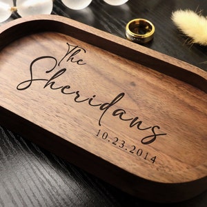 May include: A wooden oval tray with the text "The Sheridans 10.23.2014" engraved on the surface.