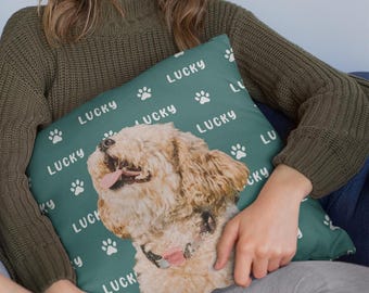 May include: A teal pillow featuring a light brown dog with its tongue out. The word "LUCKY" and white paw prints are scattered across the pillow. The dog is wearing a pink collar.