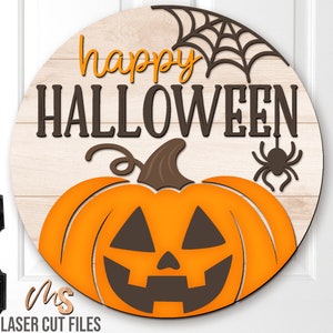 Op de afbeelding: Een rond houten bord met de tekst "happy HALLOWEEN" in bruine letters. Een gesneden oranje pompoen met een bruine steel en een jack-o'-lantern gezicht bevindt zich in de onderste helft van het bord. Een zwart spinnenweb en een zwarte spin bevinden zich in de rechterbovenhoek van het bord.