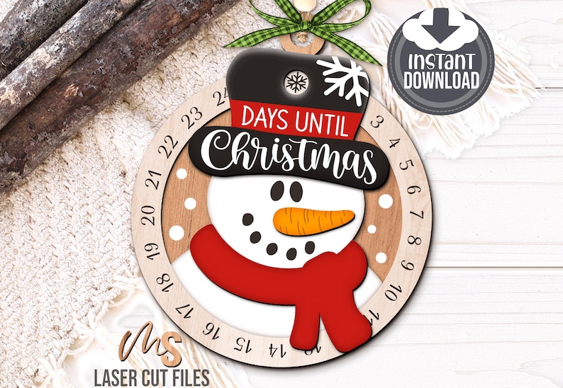 SVG Laser Cut Files for a Christmas Countdown Snowman Ornament featuring a cute snowman wearing a scarf and top hat adorned with a snowflake. His scarf covers a round turning wheel with 25 numbered days until Christmas, and his hat provides a window at the top to show how many days you have left! Turn the wheel each day until you reach the snowflake on Christmas morning!