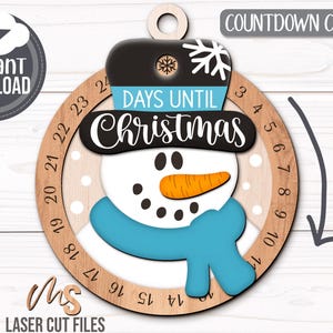 SVG Laser Cut Files for a Christmas Countdown Snowman Ornament featuring a cute snowman wearing a scarf and top hat adorned with a snowflake. His scarf covers a round turning wheel with 25 numbered days until Christmas, and his hat provides a window at the top to show how many days you have left! Turn the wheel each day until you reach the snowflake on Christmas morning!
