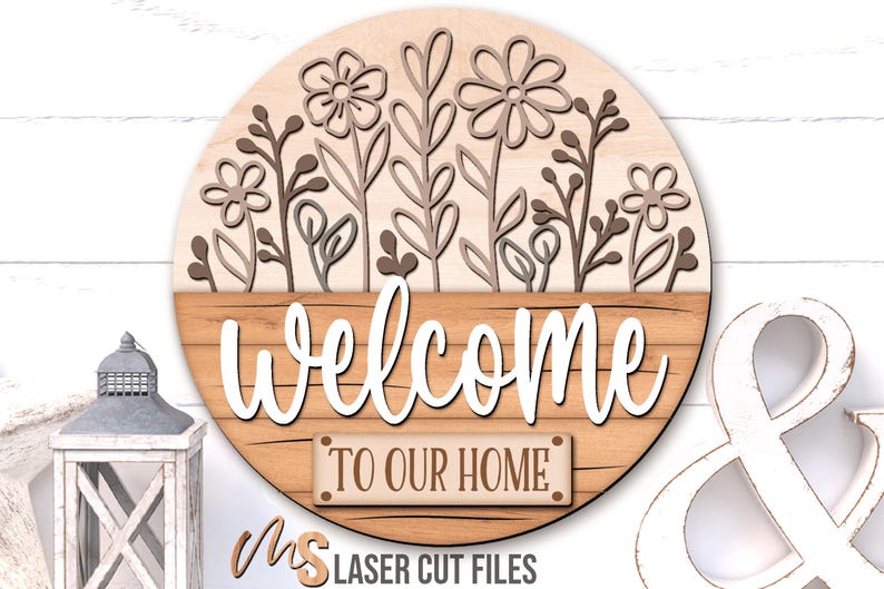 SVG Laser Cut Files for a round wood Floral Welcome Sign featuring a row of flowers filling the top half of the sign with a bottom panel that looks like a wood crate with the greeting Welcome To Our Home in decorative fonts. Make DIY Wildflower Door Hangers, Front Door Decor and Floral Porch Door Signs for spring and summer decor!