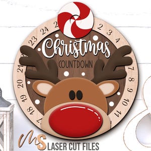 May include: Wooden Christmas countdown decoration featuring a reindeer design with a red nose and antlers. The text "Christmas Countdown" is displayed above the reindeer. A red and white peppermint candy is at the top.