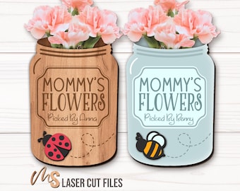 May include: Two wooden signs shaped like mason jars with flowers and text that reads "Mommy's Flowers" with a ladybug and bee on each sign.
