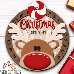 SVG Laser Cut Files for a round Christmas Countdown Sign featuring an adorable reindeer peaking over center surrounded by snow. His nose and antlers cover a round turning wheel with 25 numbered days until Christmas. A big peppermint candy holds the top of the wheel with an opening in the center to show the number of days left! Turn the wheel once each day to complete the peppermint on Christmas morning!