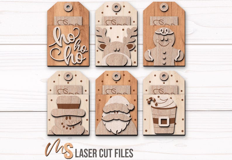 SVG Laser Cut Files for a bundle of 6 Christmas Gift Card Holders featuring cute Gift Tag shapes decorated with a Santa Claus, the text Ho Ho Ho, a Snowman, a Gingerbread Man, a Reindeer, and a Christmas Coffee Cup with spacers on the inside where you can insert your Gift Cards and money! Create festive Gift Card Holders, Money Holders, and gift Ornaments!