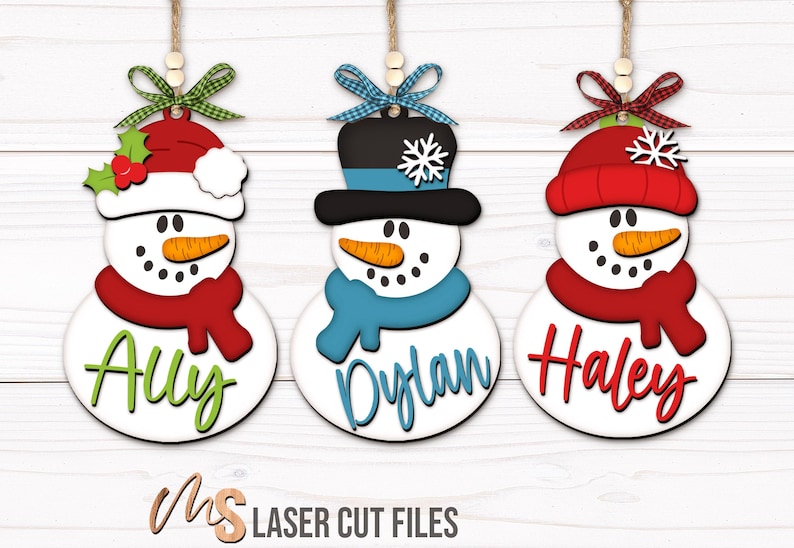SVG Laser Cut Files for a bundle of three cute Snowman Ornaments wearing a santa hat, snowman hat, and winter beanie cap with scarfs, snowflakes, and an open space to add your own custom text and names. Perfect for making custom Christmas Ornaments, Christmas Gift Tags and Name Tags for the holidays!