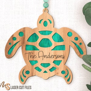 May include: A wooden turtle ornament with a teal cutout design and the text "The Andersons" in a cursive font.