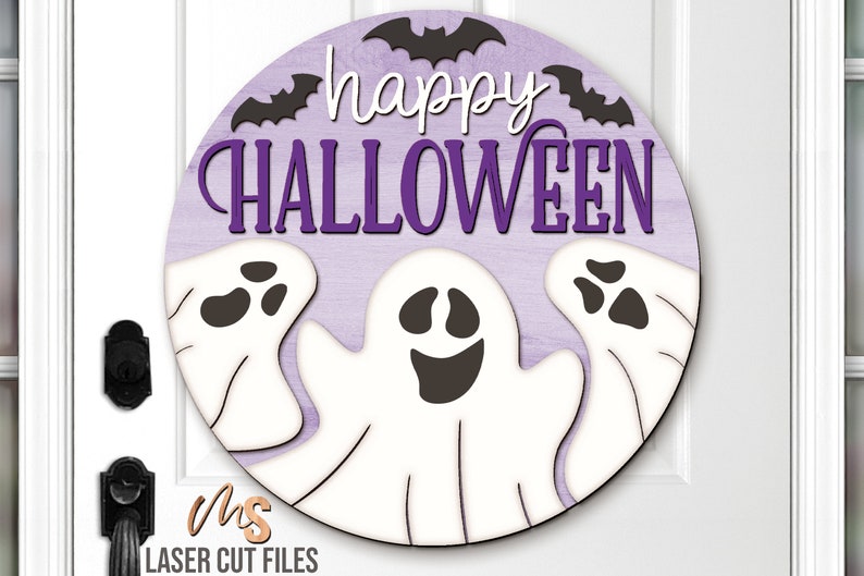SVG files for a round wood Halloween Sign with three spooky ghosts peaking up from the bottom with the phrase Happy Halloween in decorative fonts and bats flying overhead. Perfect for making spooky Halloween Door Hangers, Ghost Signs, and Halloween decor this fall season!