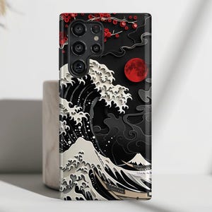 May include: Black phone case with a white wave design and a red moon. The case has a cut-out for the camera lens.