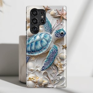 May include: A white phone case with a blue and green sea turtle design. The turtle is surrounded by white seashells and starfish.