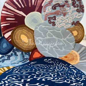 May include: A collection of colorful, round rugs with various abstract designs. The rugs feature a range of colors, including deep red, blue, brown, and gray, with patterns like concentric circles and organic shapes. The rugs are arranged in a visually appealing display.