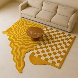 May include: A living room with a beige sofa and two distinctive rugs. One rug has a wavy, melted design in shades of yellow, the other a yellow and white checkerboard pattern. A small, round wooden coffee table sits between the sofa and rugs. The rugs are a statement piece.