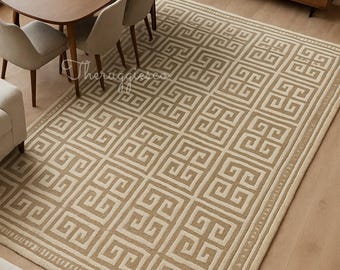 May include: Beige and cream-colored area rug with a geometric Greek key pattern. The rug is rectangular and covers a wooden floor. The rug is in a living room setting with a dining table and chairs.