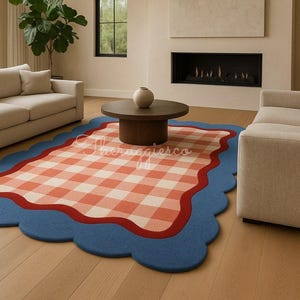 Handtufted wool rug with peach gingham center, red wavy border, and blue scalloped edge styled in a modern living room with neutral sofas.
