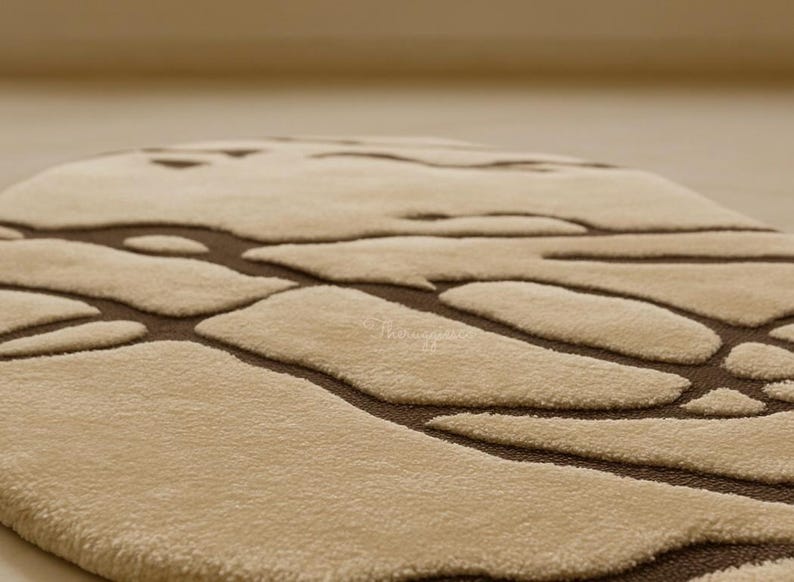 Pode incluir: Um tapete bege com um padr&atilde;o org&acirc;nico castanho. O tapete tem uma superf&iacute;cie macia e texturizada e um design moderno. O padr&atilde;o assemelha-se a formas interligadas, criando um apelo visual &uacute;nico. Adequado para salas de estar e quartos.