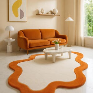 May include: A distinctive orange, freeform rug defines the living room. An orange sofa sits against a neutral wall, complemented by a white coffee table and a modern floor lamp. A framed abstract art piece hangs on the wall.