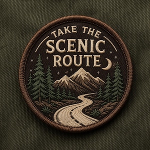May include: Embroidered patch with the text "TAKE THE SCENIC ROUTE". The patch features a mountain landscape with a winding road, pine trees, and a crescent moon. The patch is brown with a dark brown border and is set against a green background.