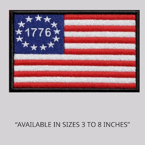 May include: Embroidered patch featuring the American flag design with red and white stripes and a blue field with white stars encircling the year "1776". The patch is rectangular with a black border and is available in sizes 3 to 8 inches.