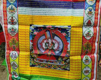 May include: A colorful Tibetan Buddhist prayer flag with intricate designs and text. The flag features a central image of a deity surrounded by detailed patterns in red, yellow, blue, and green. Decorative borders and additional religious symbols complete the design.