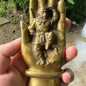 Puede incluir: Una taza de cerámica blanca con un asa negra y el texto "But First, Coffee" en negro, con una fuente de estilo manuscrito. La taza está sobre una superficie blanca.