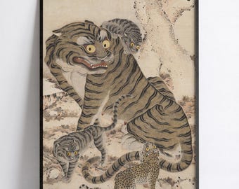 May include: A framed wall art print featuring a large tiger with yellow eyes and dark stripes, accompanied by two smaller tiger cubs and a spotted leopard cub. The scene is set against a muted, light-colored background with a tree trunk.