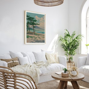 May include: A white couch with pillows and a throw blanket sits in a living room with a wooden coffee table and a potted plant. A framed print of a Japanese landscape hangs on the wall above the couch.