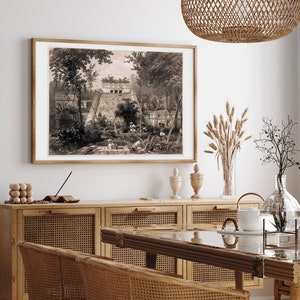 K&ouml;nnte beinhalten: Eine Vintage-Illustration einer Maya-Pyramide in einer Dschungelumgebung. Das Bild ist in einem braunen Holzrahmen gerahmt und h&auml;ngt an einer wei&szlig;en Wand &uuml;ber einem Holzschrank mit Rattan-T&uuml;ren.
