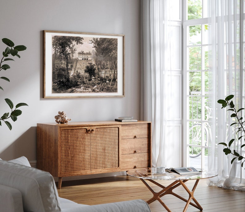 K&ouml;nnte beinhalten: Eine Vintage-Schwarzwei&szlig;illustration eines Geb&auml;udes mit B&auml;umen und einem Weg, der dorthin f&uuml;hrt. Die Illustration ist gerahmt und h&auml;ngt an einer Wand &uuml;ber einem Holzkasten.