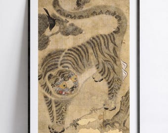 May include: A framed wall art print featuring a stylized painting of a tiger with dark stripes on a tan background. The tiger is depicted with large, round yellow eyes and a small black bird perched on a branch in the upper left corner.