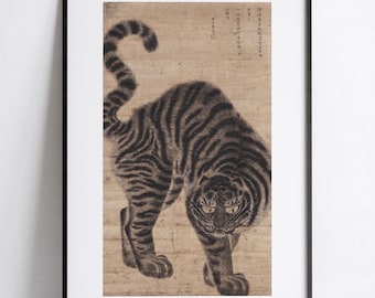 May include: A framed wall art print featuring a tiger with dark stripes on a light tan background. The tiger is depicted in a hunched, prowling stance with its tail raised. The artwork includes vertical columns of East Asian calligraphy and a small red seal mark in the upper right corner.