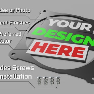 May include: A black metal fan grill with the text "YOUR DESIGN HERE" in white, green, and red. The grill includes screws for installation.