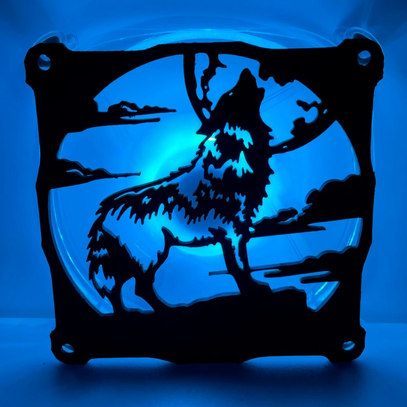 May include: A black silhouette of a wolf howling at the moon, cut out of a computer fan. The fan is illuminated with blue light.