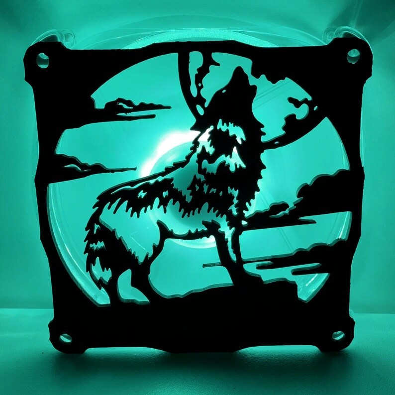 May include: A black silhouette of a wolf howling at the moon, cut out of a computer fan. The fan is lit from behind with a bright teal light.
