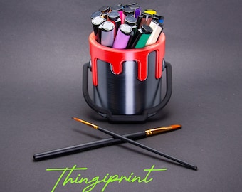 Portalápices con diseño de cubo de pintura en diferentes colores.