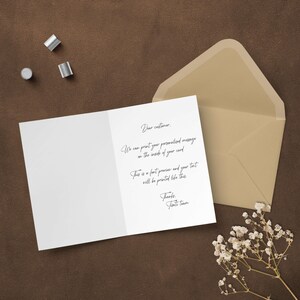 The inside of a custom greeting card showing a preview of a personalized printed message, laid out on a rustic brown surface next to a premium kraft envelope and dried floral decor.