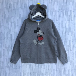 May include: A gray zip-up hoodie with a vintage Mickey Mouse graphic on the front. The hoodie has a hood with attached ears.